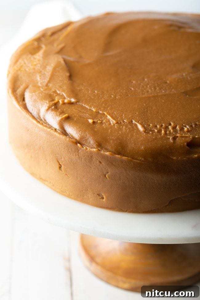 A Southern caramel cake beautifully covered in smooth, rich caramel frosting, ready for chilling before serving.