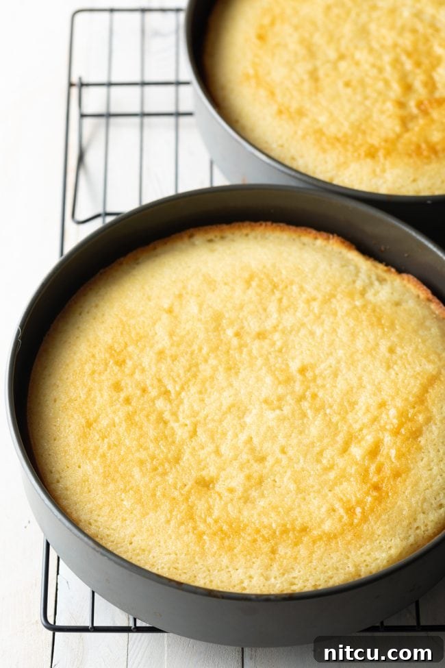 Freshly baked cake layers cooling on a wire rack after being removed from the oven, preparing for the next step in the Southern caramel cake recipe.