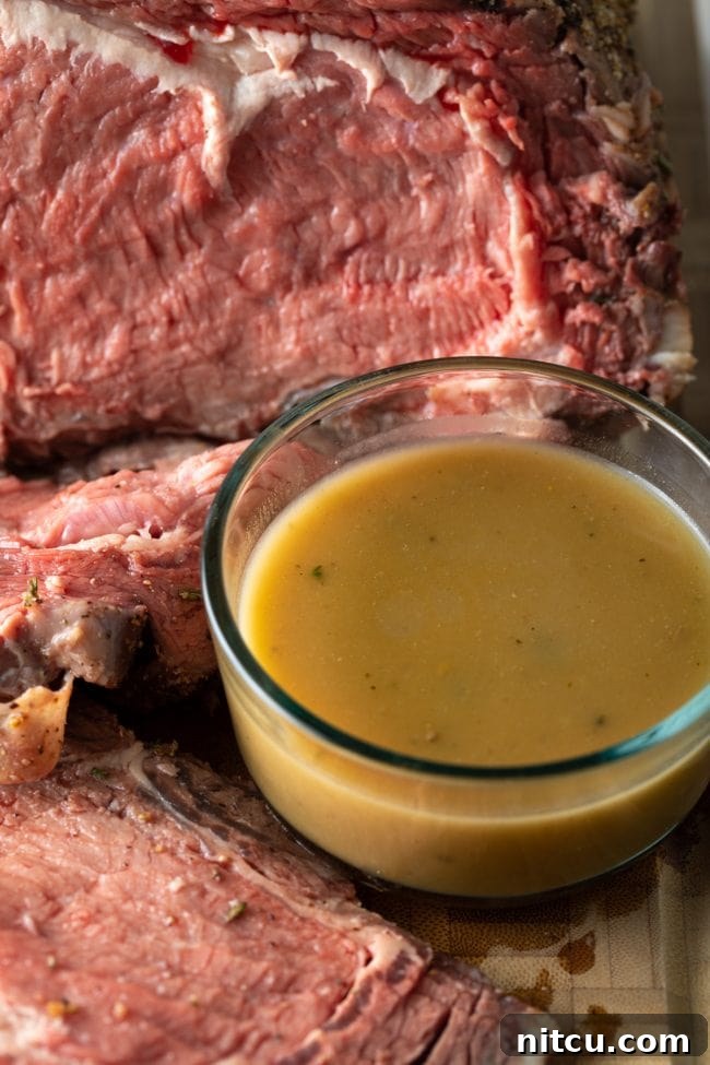 Homemade au jus with prime rib resting on the smoker