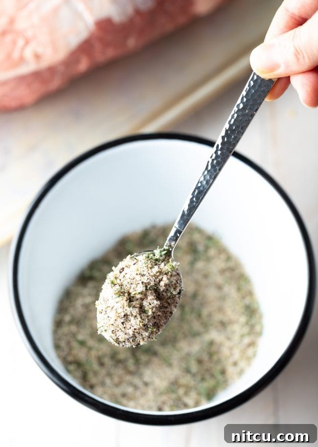 Bowl of seasoning for smoked prime rib, with a spoon lifting a portion