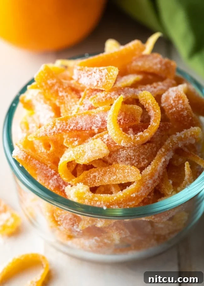 Close up of perfectly crafted candied orange peel in a elegant bowl, showcasing its bright color and sugary coating.