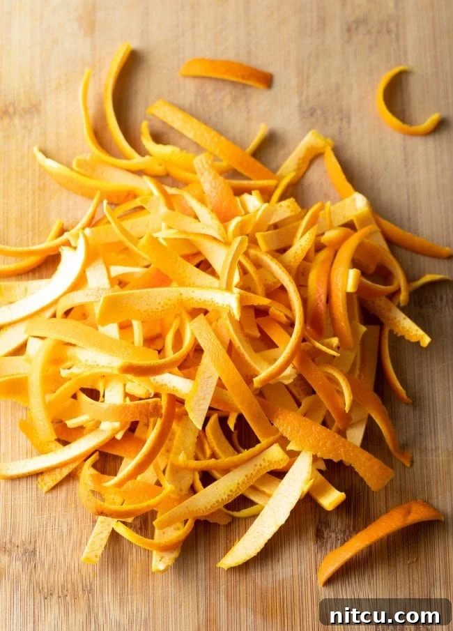 Strips of fresh orange rind, precisely cut and ready for the caramelisation process to become candied orange peel.