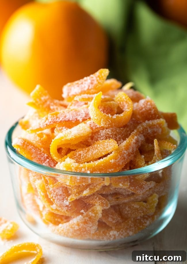 Close up view of the easy candied orange peel recipe presented beautifully in a small glass bowl.