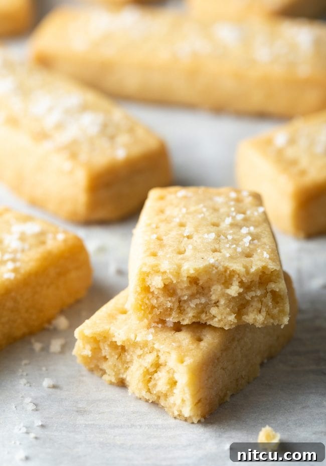 Scottish Shortbread Recipe - Two shortbread cookies broken in half and stacked on top of each other. 