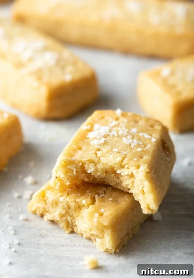 Scottish shortbread cookies stacked on top of each other with one piece missing a bite. 