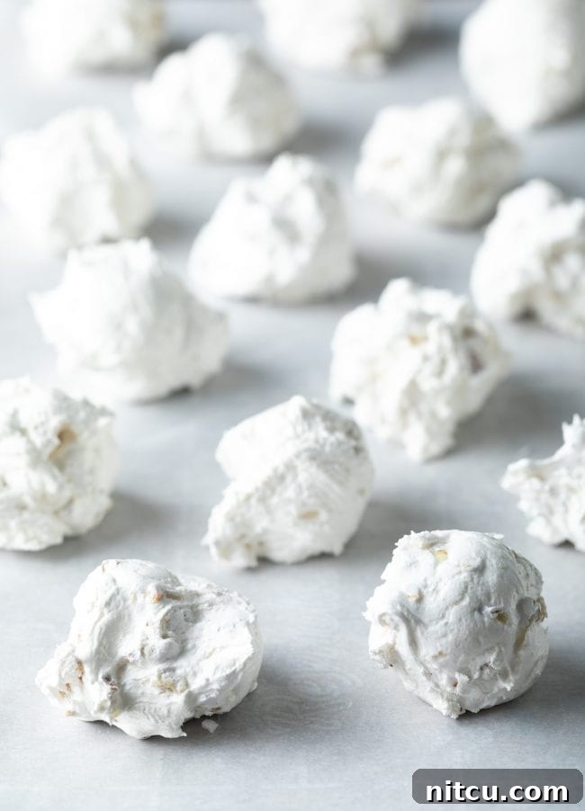 Divinity candy scooped onto a baking sheet lined with parchment paper.