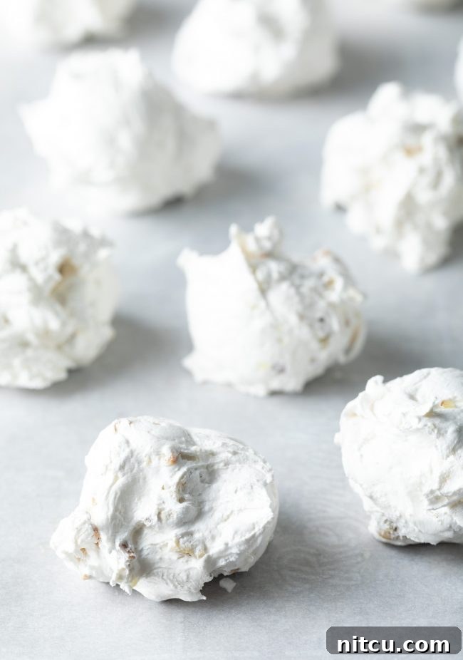 Close up of meringue dolloped onto a baking sheet.