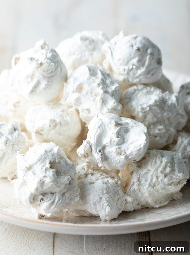 Fluffy pecan and nougat divinity candy piled up on a plate.