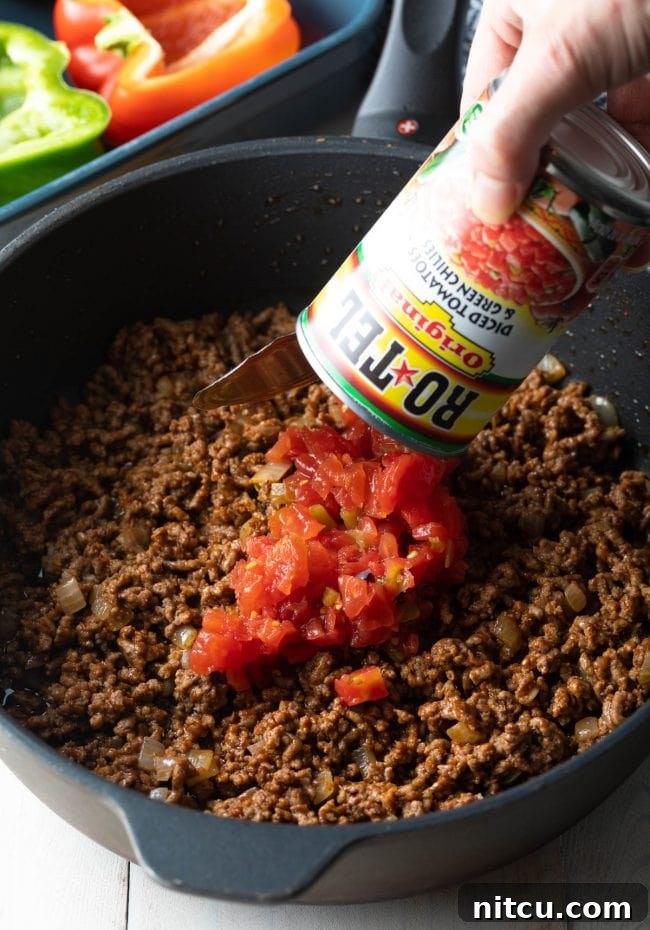 rotel and ground beef in pan for stuffed pepper filling