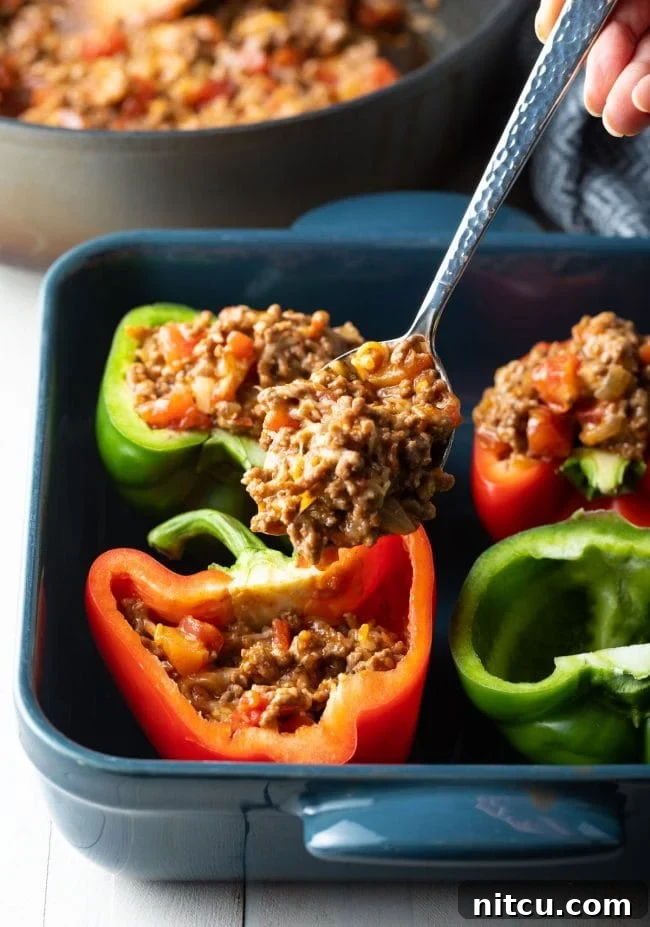 filling each pepper with meat and cheese filling