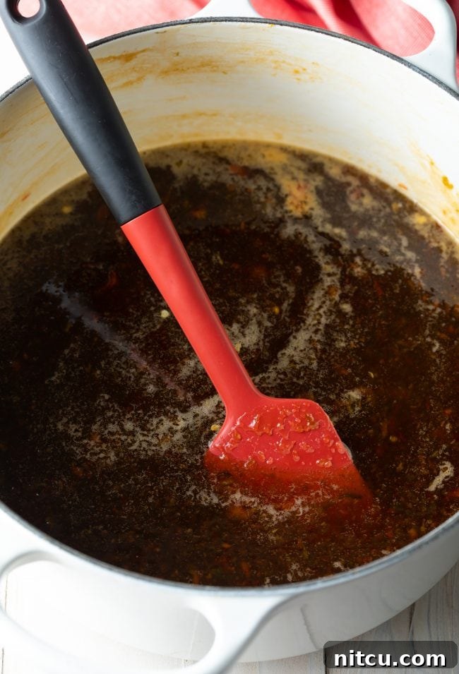 Spatula blending pectin and pepper blend, ensuring smooth consistency.