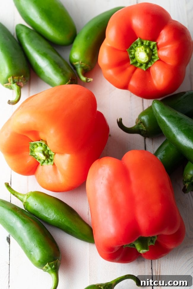 Jalapeno and bell peppers on a countertop, fresh ingredients.