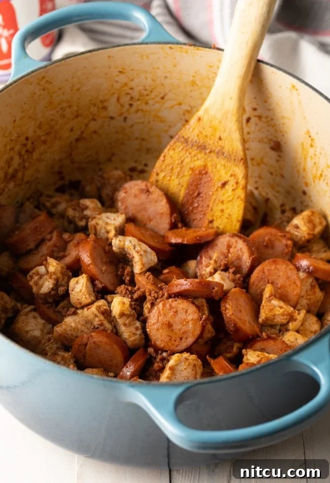 A wooden spoon stirring the pork and black bean stew in a large stew pot.