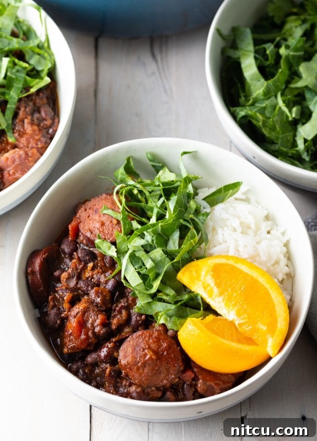 A bowl of pork and black bean stew topped with orange slices and shredded greens. Bowls of extra garnishes and the soup pot are in the background.