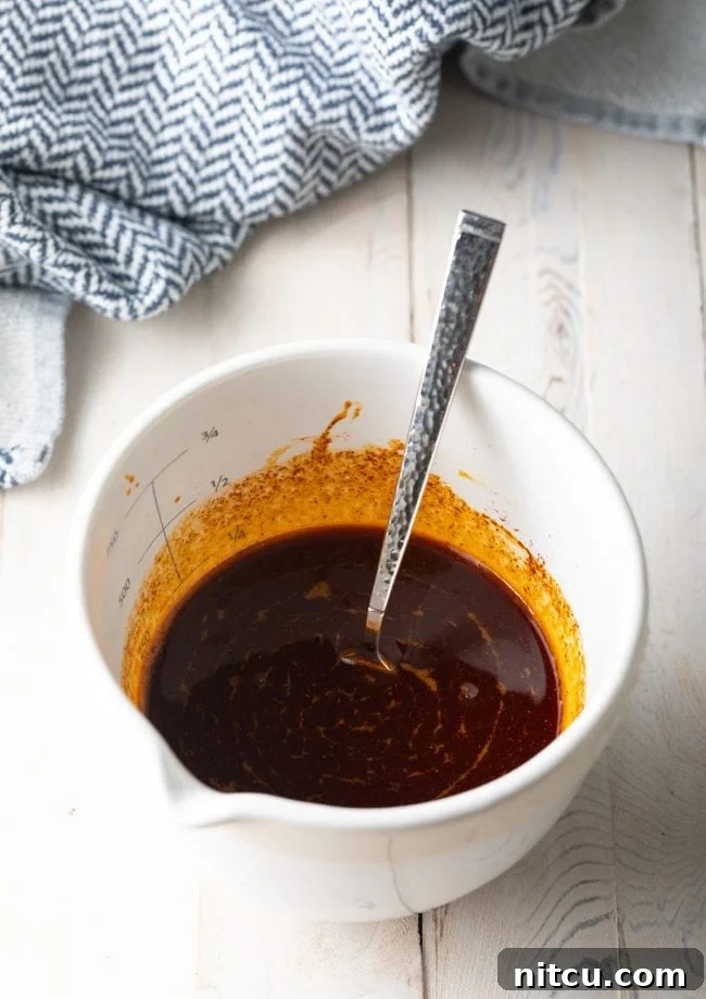 Spices and warm fry oil being mixed together in a bowl to create the signature Nashville hot sauce.