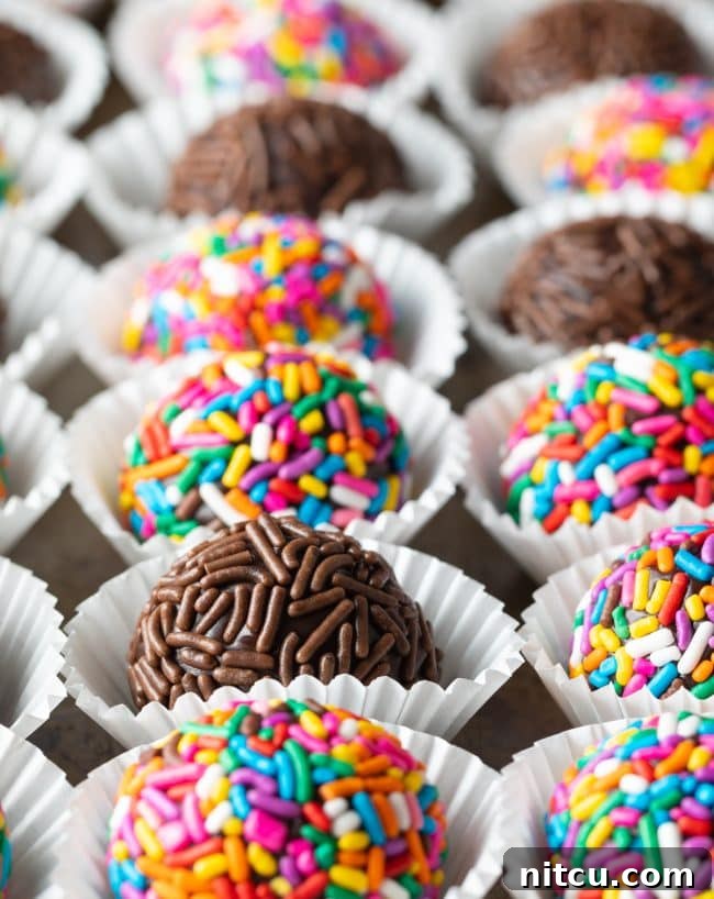 Closeup of colorful Brazilian truffles arranged onto a tray, featuring a variety of sprinkle colors and patterns.