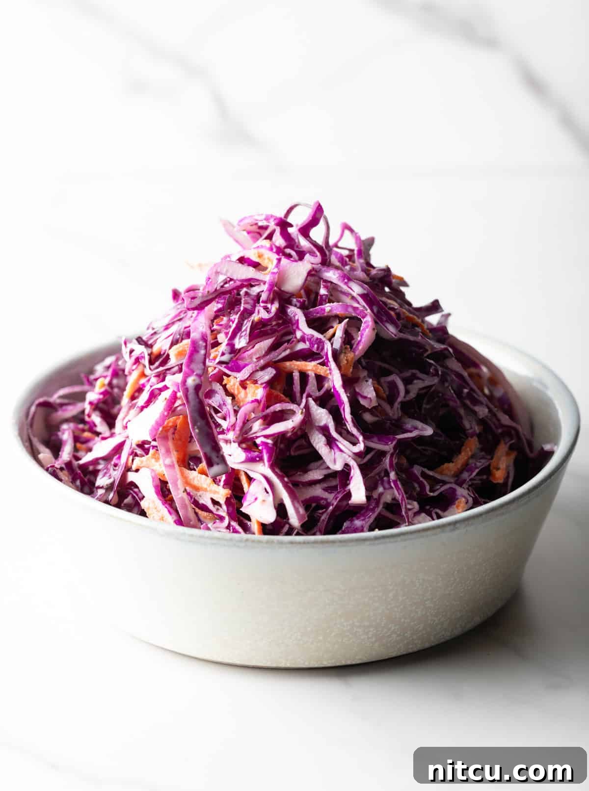 A white bowl filled with a red cabbage slaw recipe.
