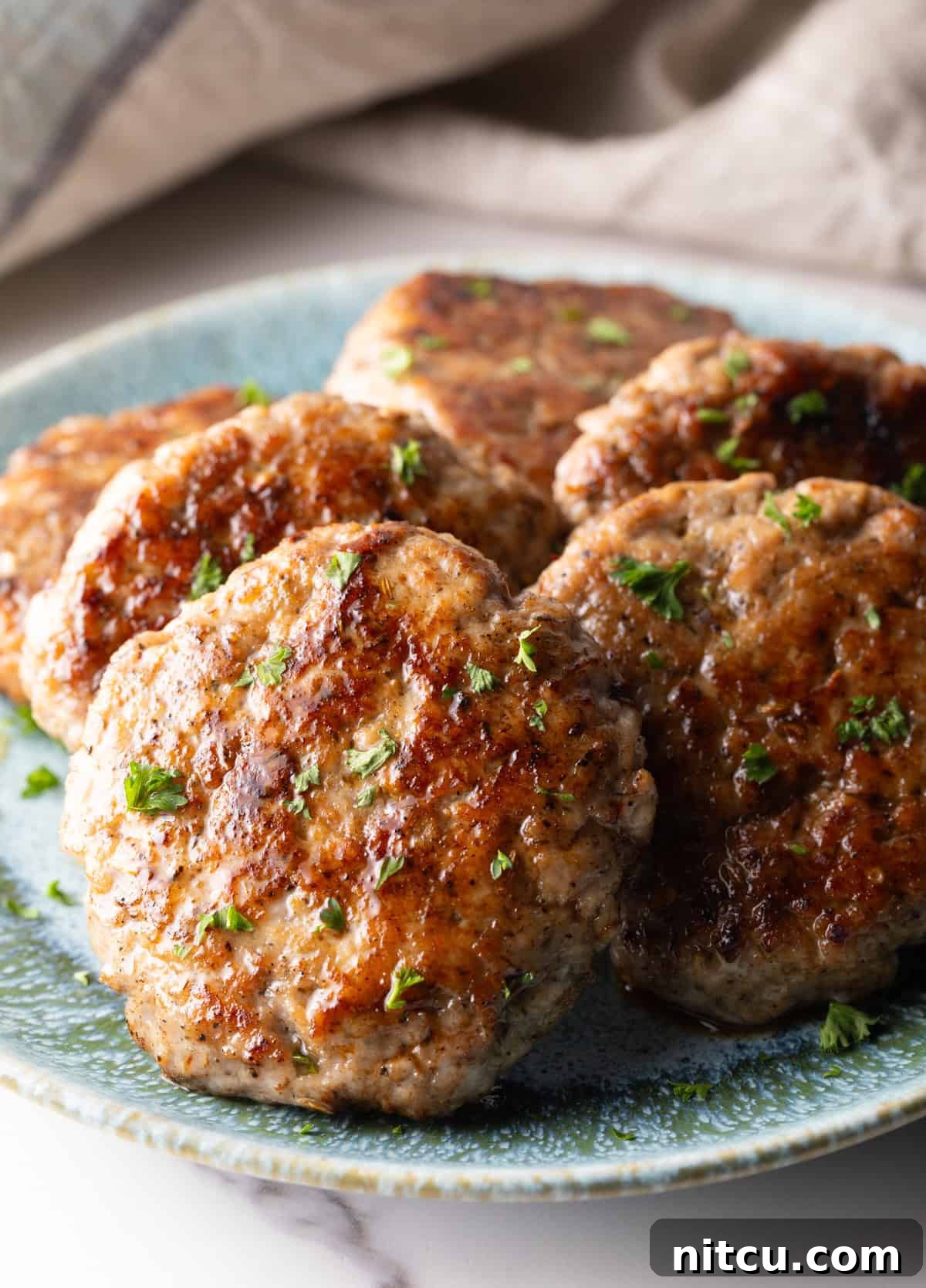 Slices of an easy homemade breakfast sausage recipe lined up in a circle on a blue plate.