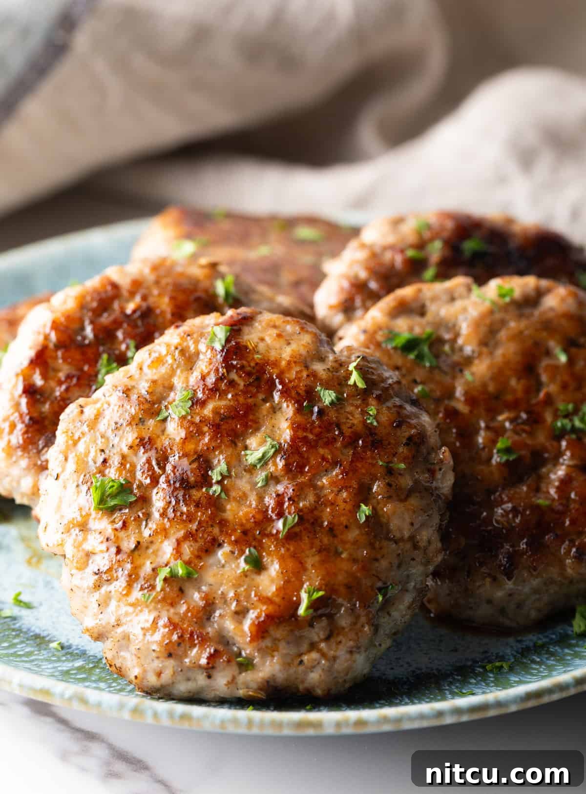 Slices of an easy homemade breakfast sausage recipe lined up in a circle on a blue plate.
