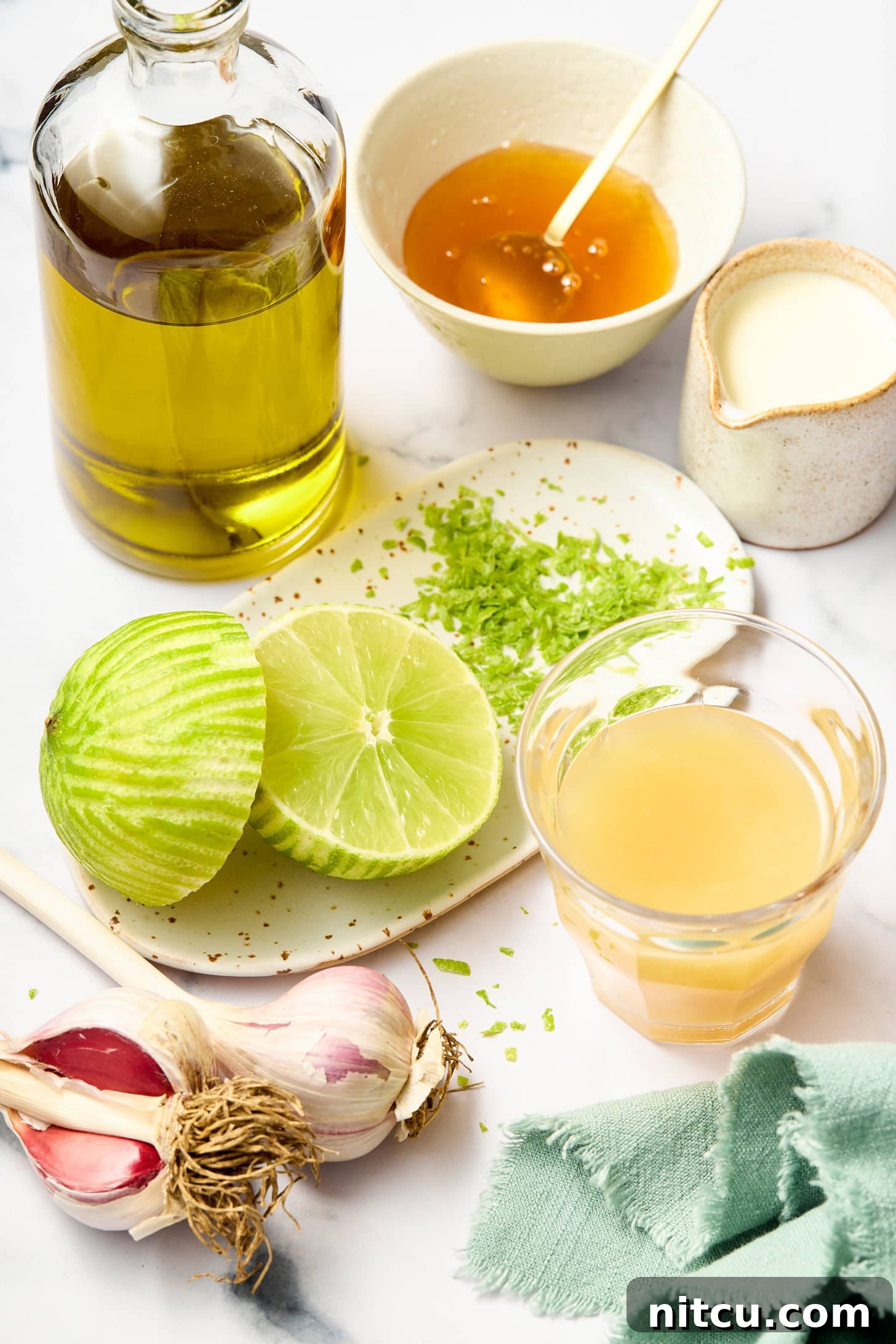 Zested limes, lime juice, honey, olive oil, and seasonings are prepared for a lime dressing recipe.