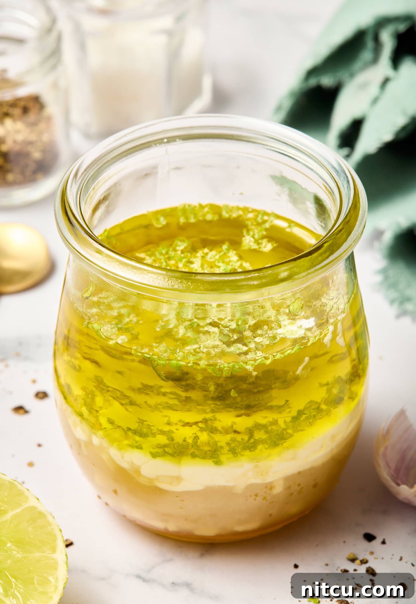 All lime salad dressing ingredients in a glass jar, waiting to be combined.