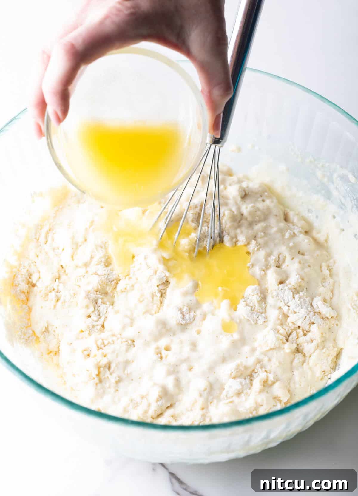 adding melted butter to the pancake mix