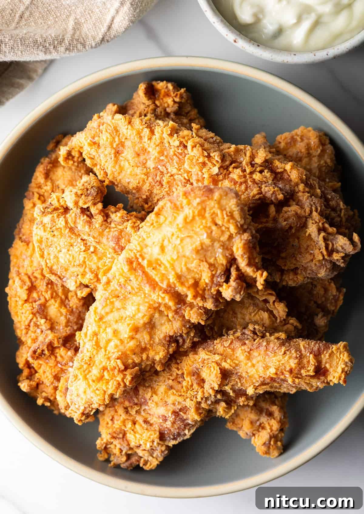 Crispy Deep-Fried Chicken Tenders Recipe That Delivers 9 An overhead shot of a bowl filled with a deep fried chicken tenders recipe.
