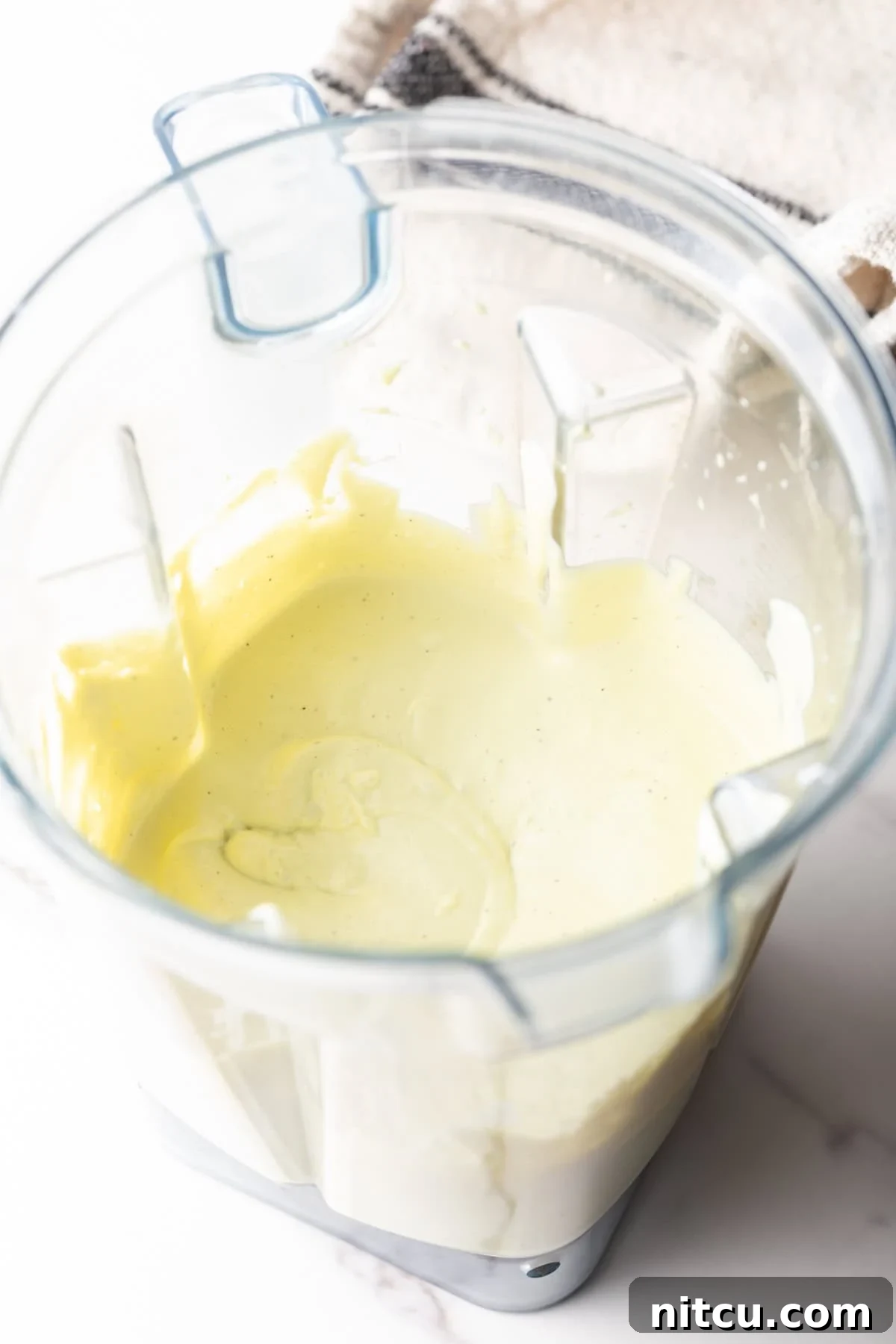 An avocado lime ranch dressing recipe is being made in a blender.